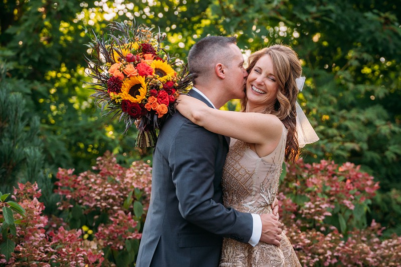 groom kissing brides cheek 